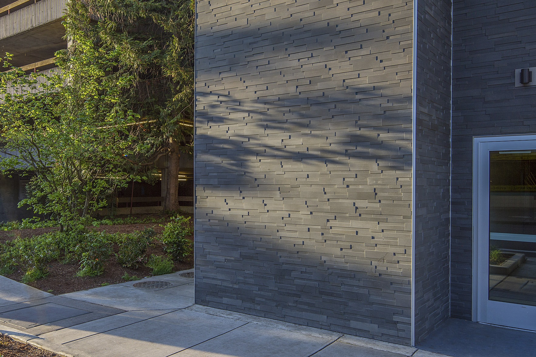Norstone Grey Aksent 3D Stone Veneer used on a commercial facade with glass door entryway